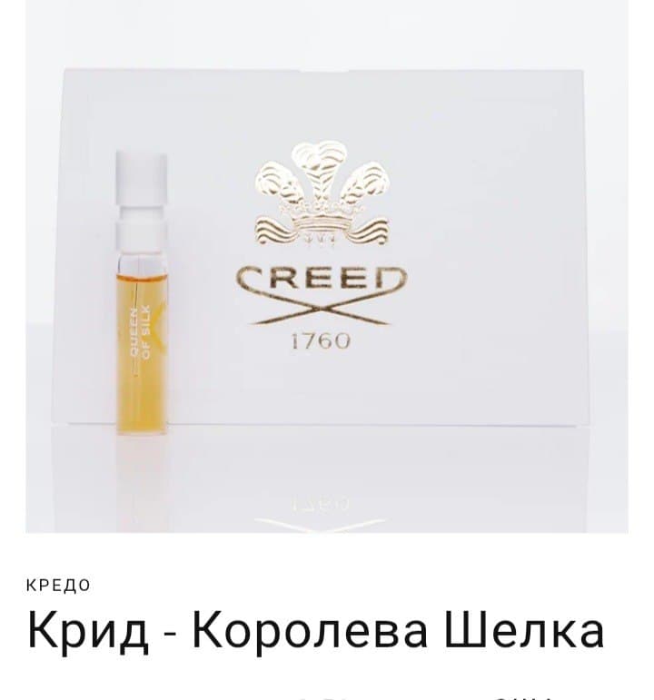 Маленький флакон духов Creed Queen of Silk на фоне белой упаковки с золотым логотипом.