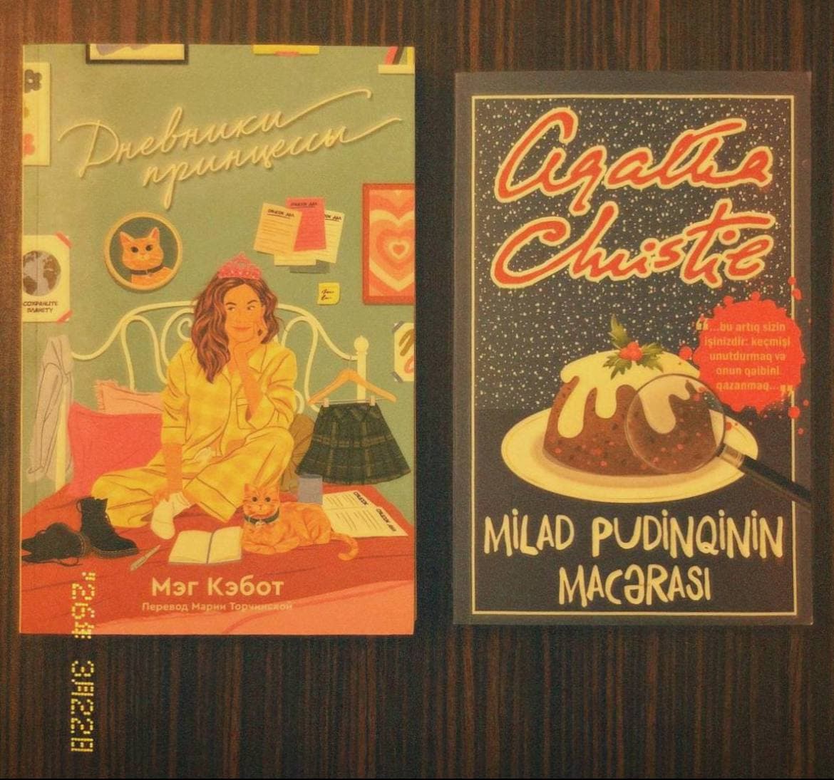 Две книги на столе: "Дневники принцессы" и "Agatha Christie - Milad pudingin macərası".