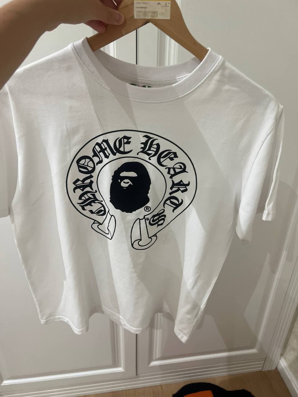Белая футболка с черным принтом "CHROME HEARTS" на передней части.