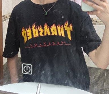 Черная футболка с принтом "Thrasher" на человеке.