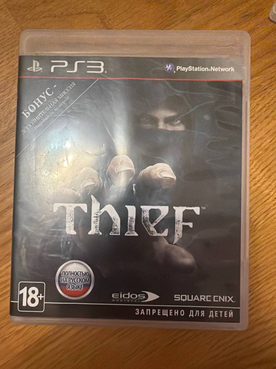 Коробка с игрой Thief для PlayStation 3 с русским текстом и возрастным ограничением 18+.
