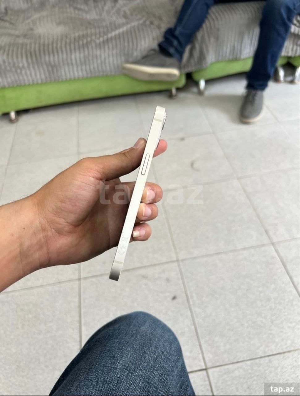 Рука держит iPhone 13 цвета Starlight, вид сбоку с кнопкой громкости.