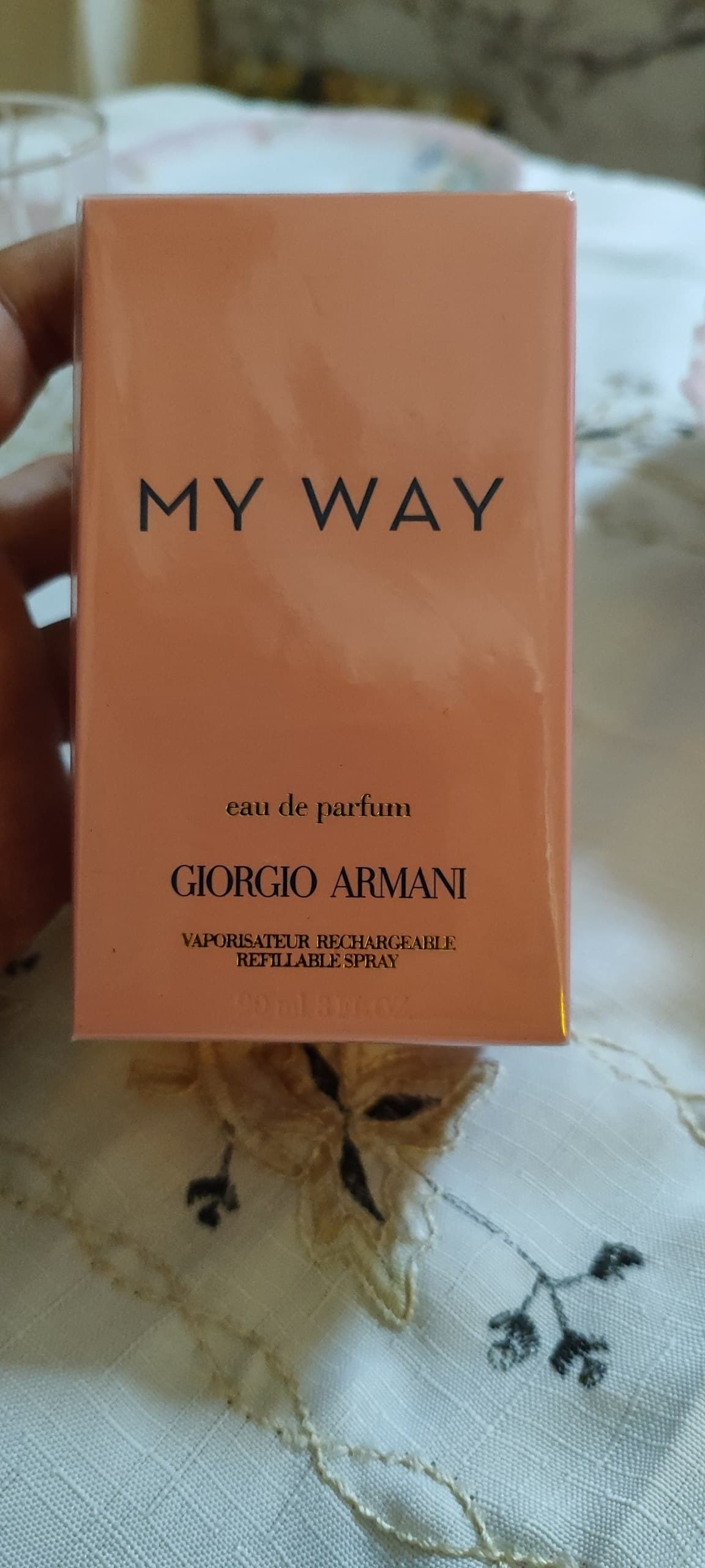 Коробка парфюма My Way от Giorgio Armani персикового цвета в руке.
