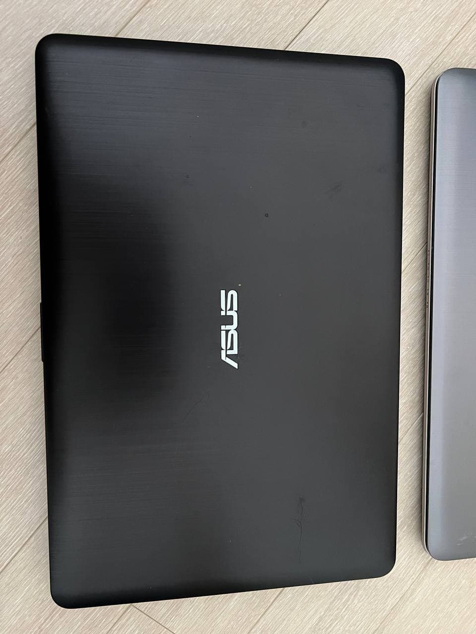 Закрытый черный ноутбук ASUS с логотипом на крышке.