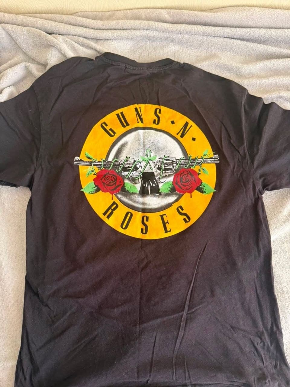 Черная футболка с крупным цветным принтом "Guns N' Roses" на спине.