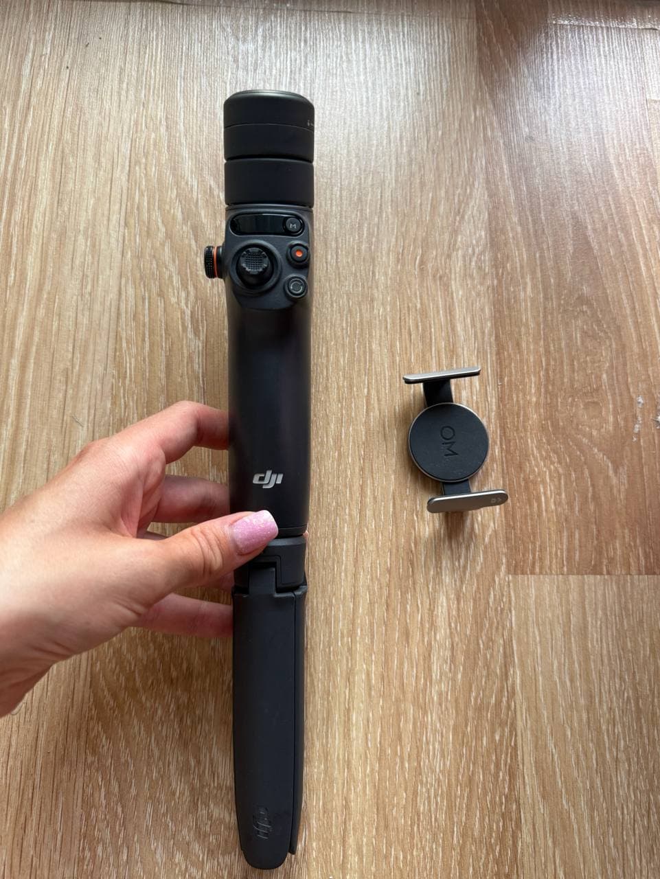 Стабилизатор DJI Osmo Mobile 6 и держатель для смартфона на деревянном полу.
