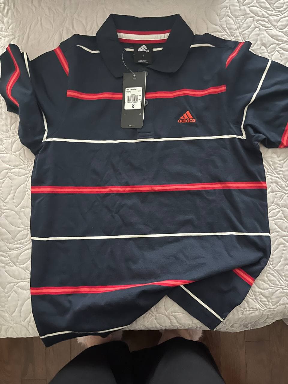 Темно-синяя поло-майка с красными и белыми полосами и логотипом Adidas.