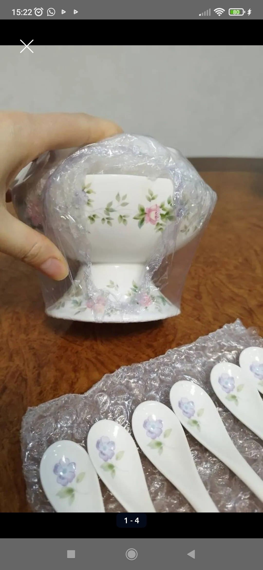 Фарфоровая чаша с цветочным узором и шесть фарфоровых ложек с цветочным рисунком на деревянном столе.