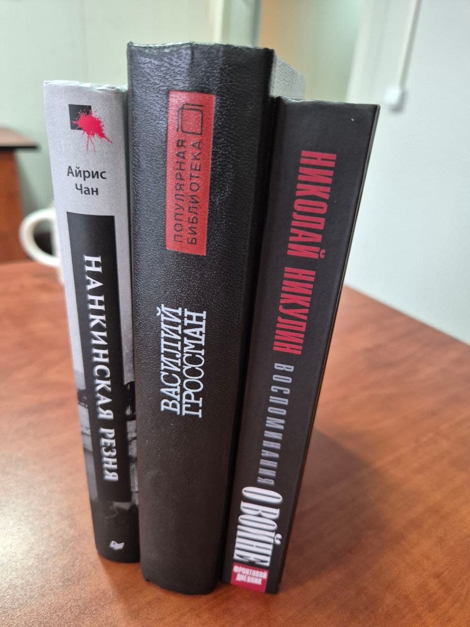 Три книги военной документалистики на столе, видны корешки с названиями.