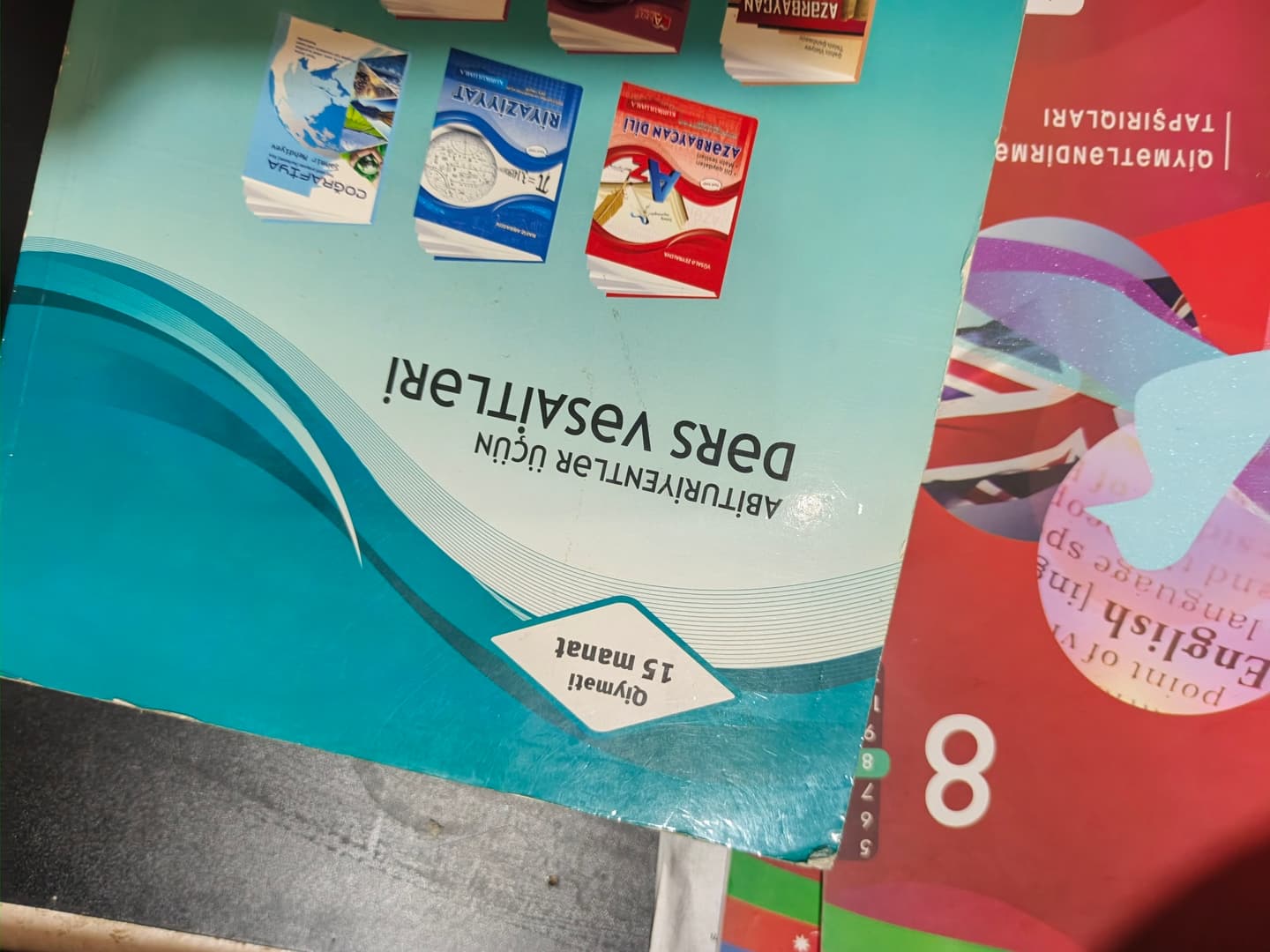 Несколько учебников по английскому языку с разноцветными обложками, лежащих на столе.