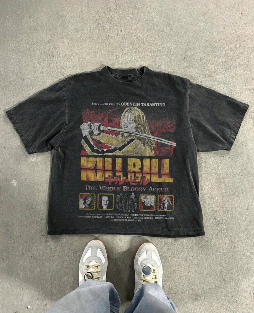 Черная футболка с принтом из фильма "Kill Bill" на сером фоне.