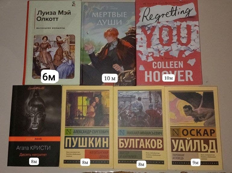 Семь книг разложены на столе, среди них "Маленькие женщины" с заметками внутри.